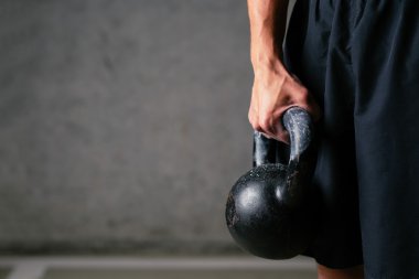 kettlebell ağırlık tutarak atlet