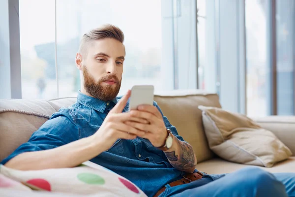 Hipster textning på sin smartphone — Stockfoto