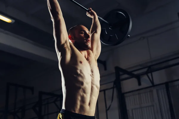 Mladý muž barbells zvedání v tělocvičně — Stock fotografie