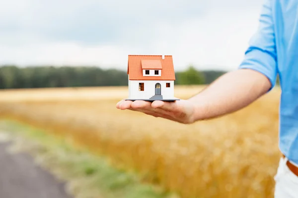 Hand met miniatuur huis — Stockfoto