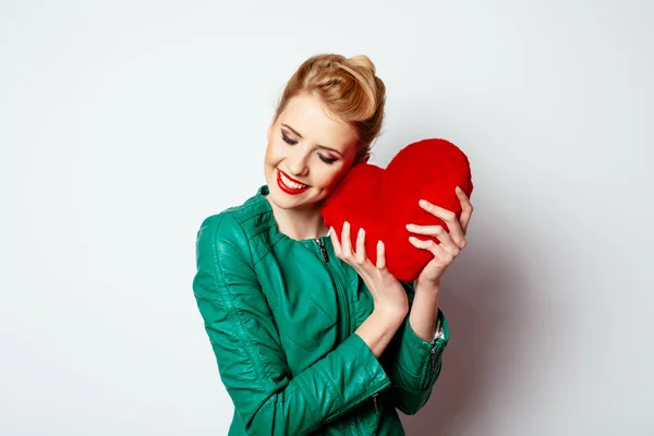 Vrouw knuffelen hart gevormde kussen — Stockfoto