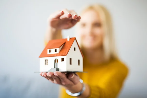 Mulher segurando casa estatueta — Fotografia de Stock