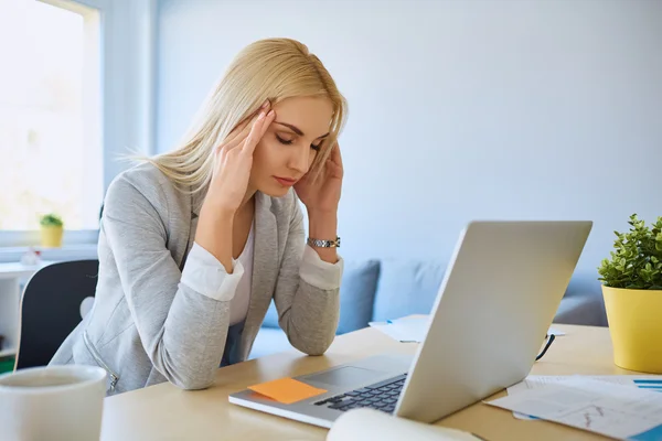 Businesswoman with headache working — Stock Photo, Image