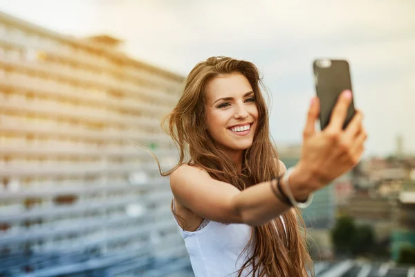 Frau macht Selfie auf Wurzelstock Stockfoto