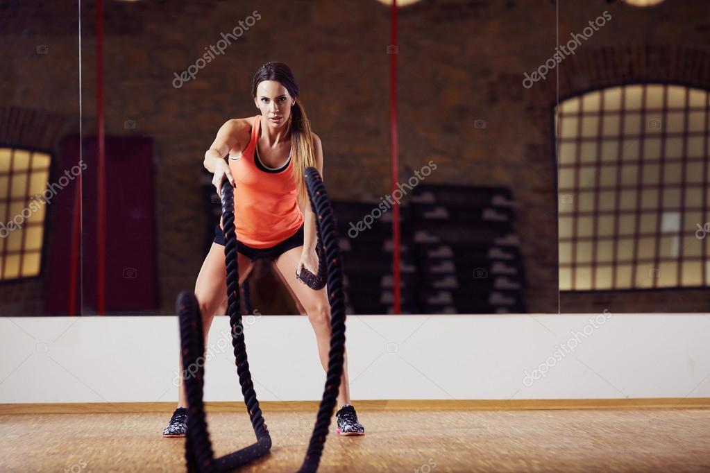 Woman doing battle rope exercise Stock Photo by ©baranq 115184954
