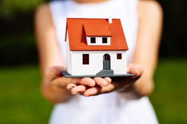 Bir minyatür ev tutan kadın