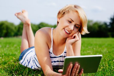 Tablet kullanan genç bir kadın.