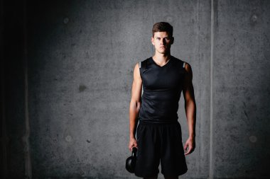 Bir kettlebell tutan vücut geliştirmeci