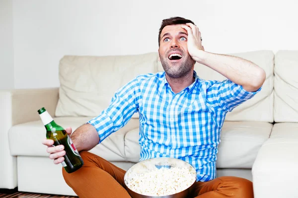 Sports fan watching game on tv — Stock Photo, Image