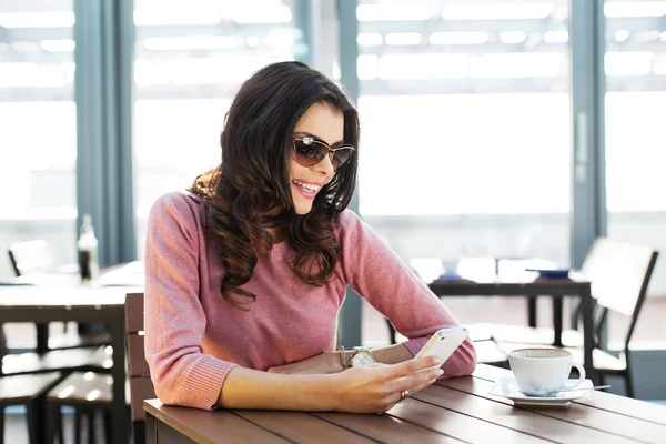 Kvinna i café håller mobiltelefon — Stockfoto