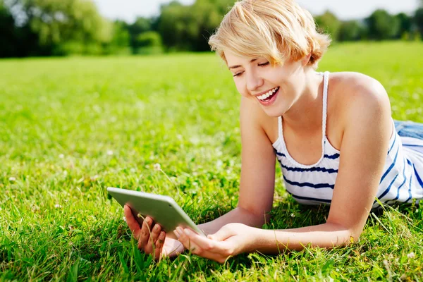 Jonge vrouw die een tablet gebruikt — Stockfoto