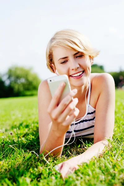 Жінка на траві, прослуховування музики — 스톡 사진