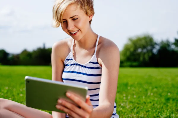 Frau auf Gras mit Tablet — Stockfoto