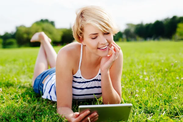 Jonge vrouw die een tablet gebruikt — Stockfoto