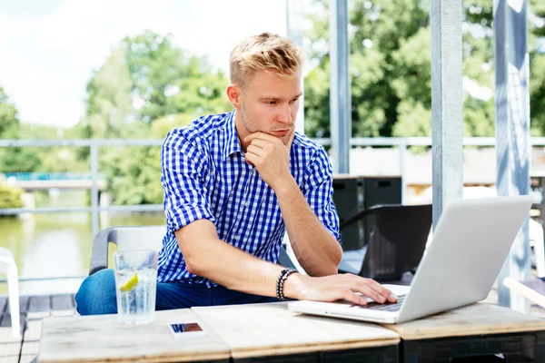 Hombre leyendo información sobre un ordenador portátil — Foto de Stock