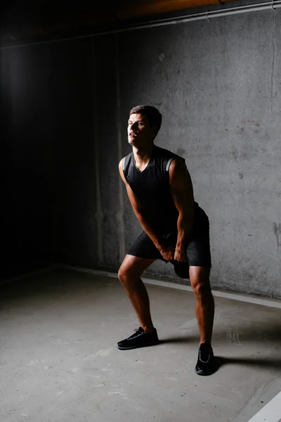 Muskelkräftiger Bodybuilder mit einer Kettlebell — Stockfoto
