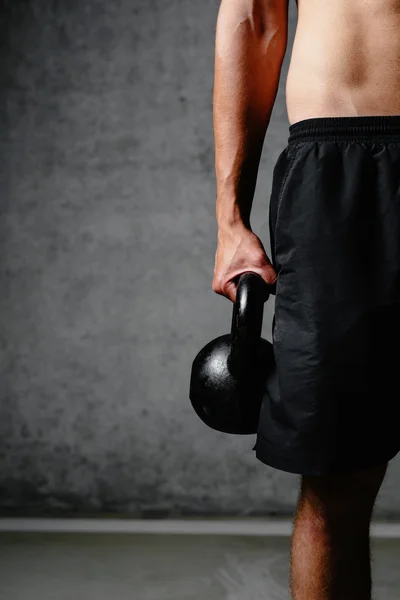 Muscular arm holding a kettlebell — Stock Photo, Image