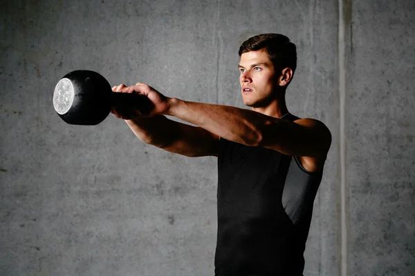 Muskelsportler trainiert mit Kettlebell — Stockfoto