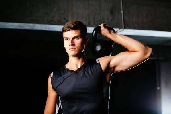 Fisiculturista levantando um kettlebell — Fotografia de Stock