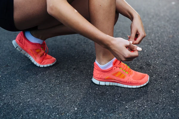 Läuferin schnürt ihre Schuhe — Stockfoto