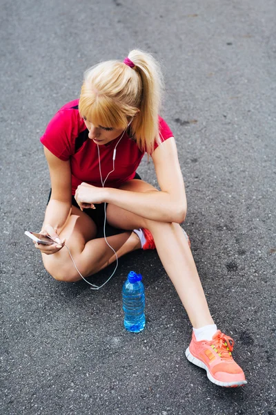 Corredor femenino eligiendo canciones — Foto de Stock