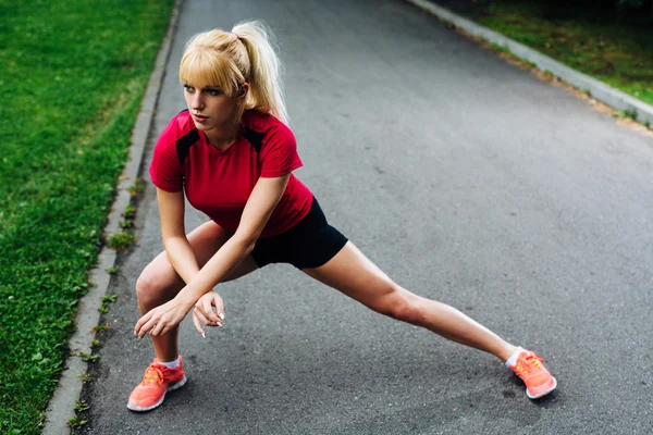 Mulher aquecendo antes de correr — Fotografia de Stock