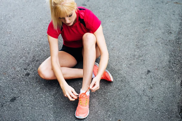 Vrouwelijke atleet vetersluiting van haar schoenen — Stockfoto