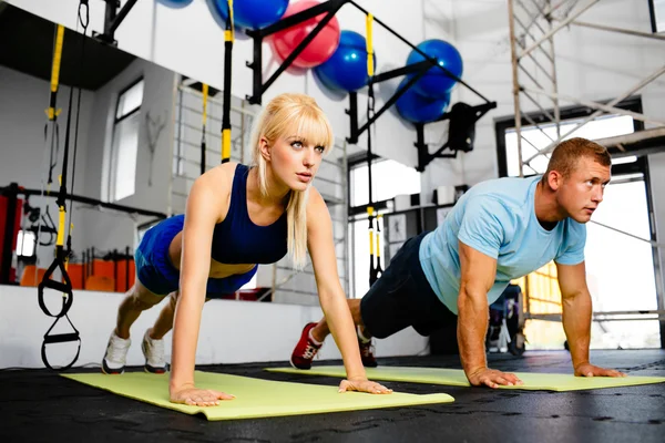 Mujer haciendo flexiones con entrenador — Foto de Stock