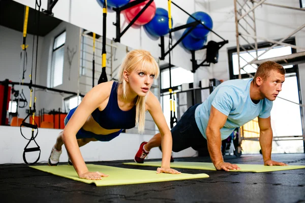 Woman doing pushups with trainer — Stock Photo, Image