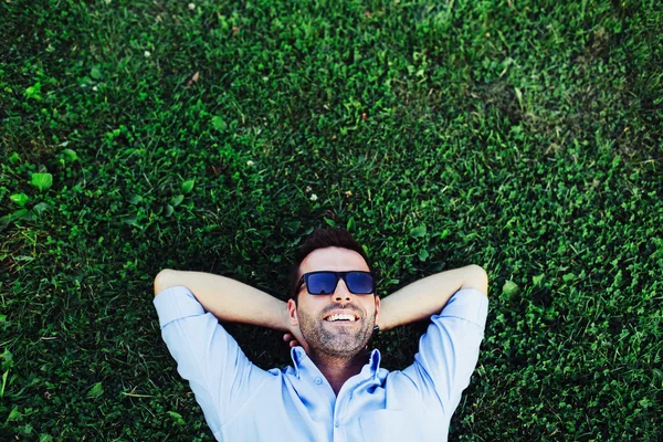 Adam çimenlerin üzerinde rahatlatıcı — Stok fotoğraf