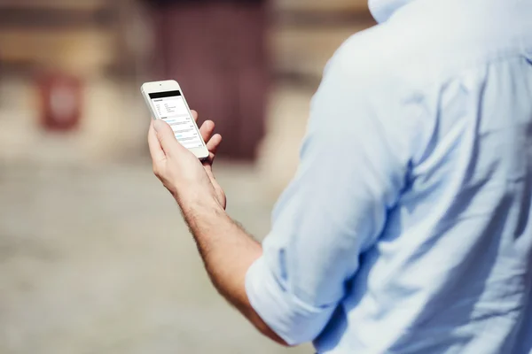 Homem segurando um smartphone — Fotografia de Stock