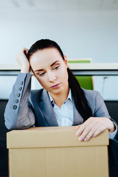 Woman with a carton on her lap — Stock Photo, Image