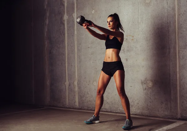 Sportvrouw uit te werken met kettlebell — Stockfoto