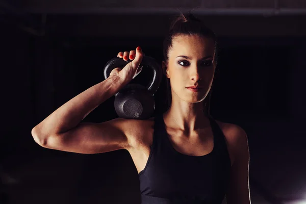 Vrouwelijke bodybuilder toning haar arm — Stockfoto