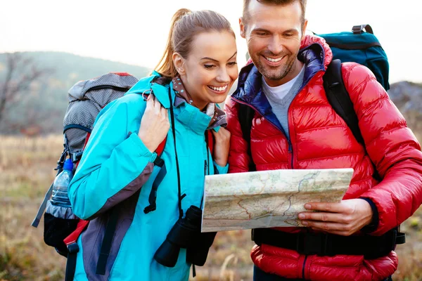 Happy couple reading map — Stock Photo, Image