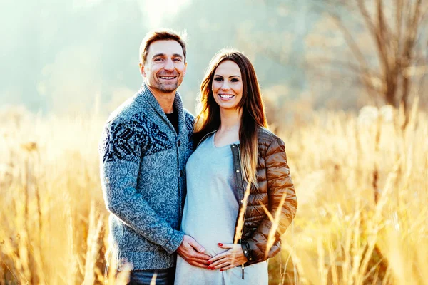 Pregnant couple in wheat field — Stock Photo, Image