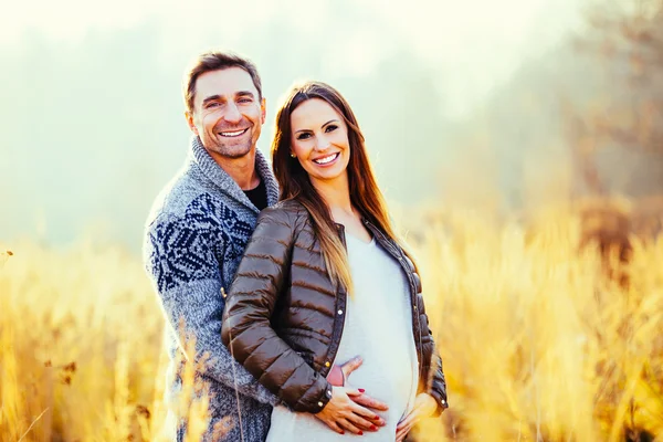 Casal grávida no campo de trigo — Fotografia de Stock