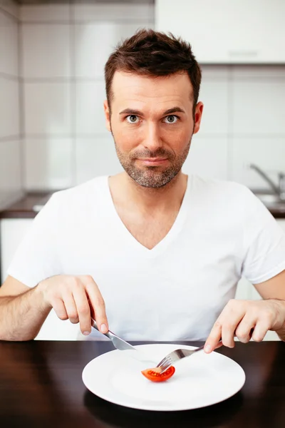 Mann isst winzige Portion Nahrung — Stockfoto