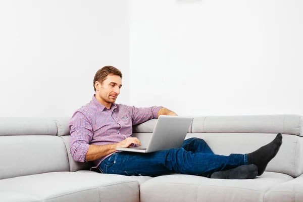 Man på soffan med laptop — Stockfoto