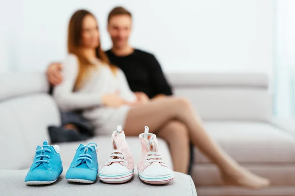 Pareja embarazada mirando botas de bebé — Foto de Stock