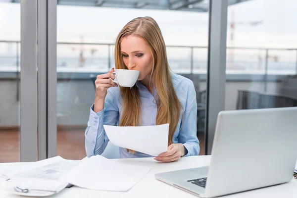 Femme d'affaires faisant de la paperasse et buvant du café — Photo