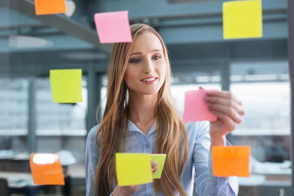 Empresaria mirando notas pegajosas — Foto de Stock