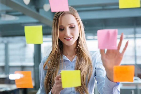 Empresaria mirando notas pegajosas — Foto de Stock