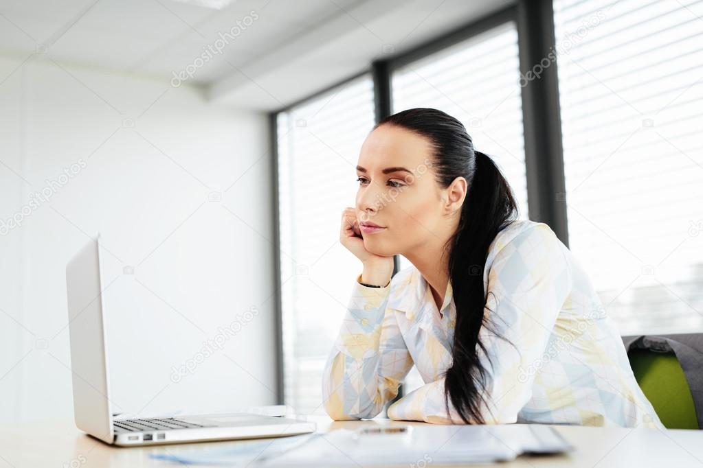 Female office worker looking at laptop