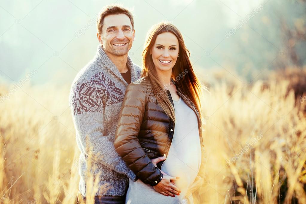 Pregnant couple in wheat field