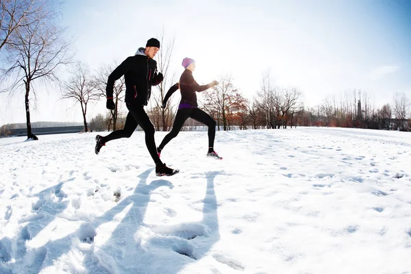 Paar läuft auf Schnee — Stockfoto