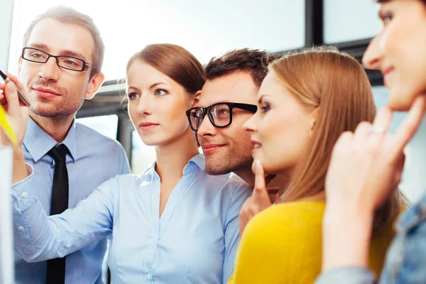 Salespeople looking at board — Stock Photo, Image