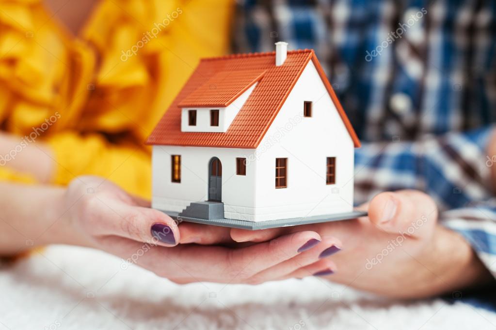 Couple holding house miniature