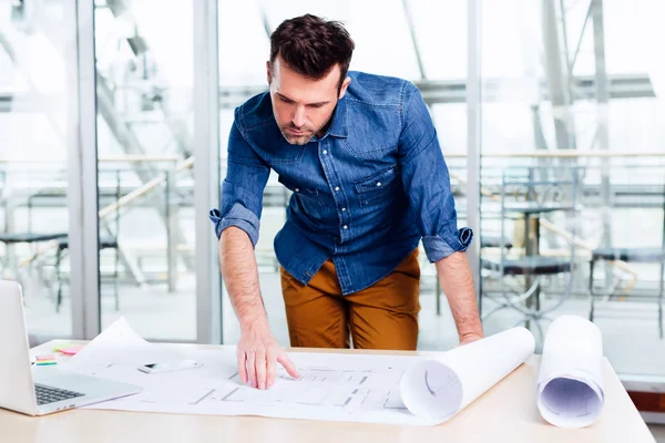 Arquitecto mirando un plano de una casa — Foto de Stock