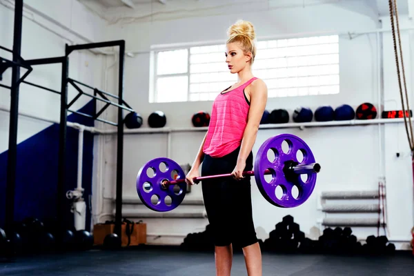 Vrouw opleiding met halters in sportschool — Stockfoto